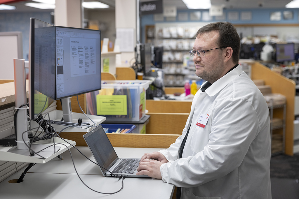 Daryl Fahrner works at a computer in a pharmacy setting