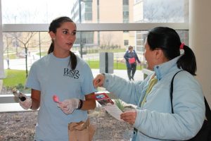 A WSPS student volunteer at the Health Sciences MedDrop Scoop event shared MedDrop information and ice cream with an attendee.