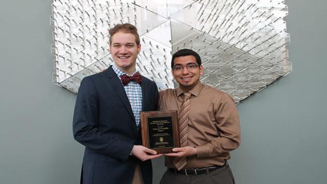 Student Senate Chairperson, Daniel Bruckbauer, DPH-4, (left) presents Edward Portillo, assistant faculty associate in the Pharmacy Practice Division, with the 2016-2017 Student Senate Teaching Excellence Award.