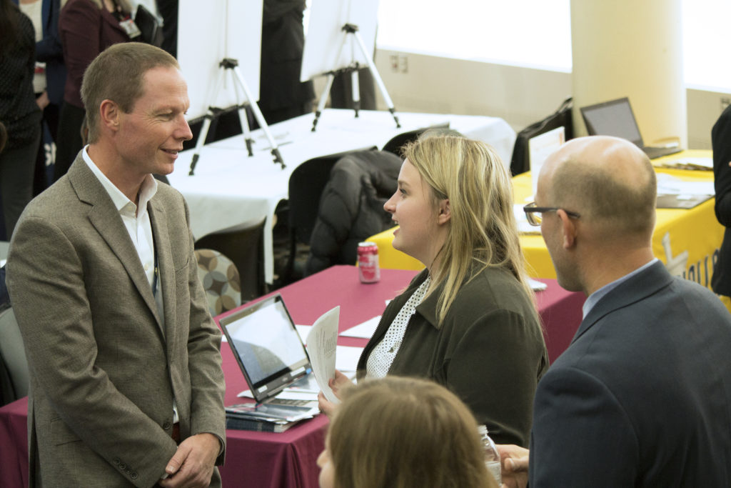 A UW-Madison PharmD student speaking with a potential employer at the School's 2018 Career Fair.