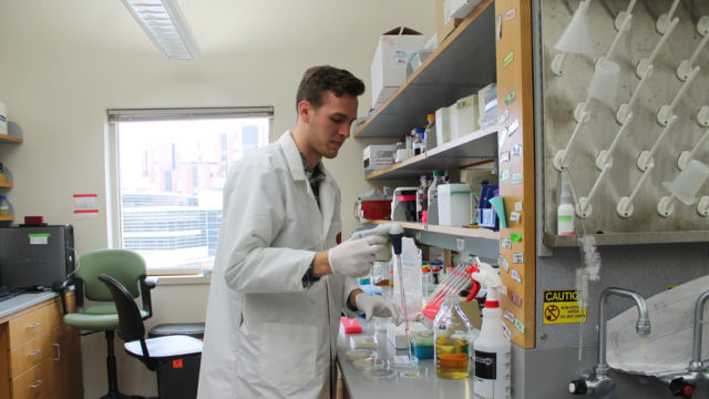 Aaron Rottier putting some substance into petri dishes