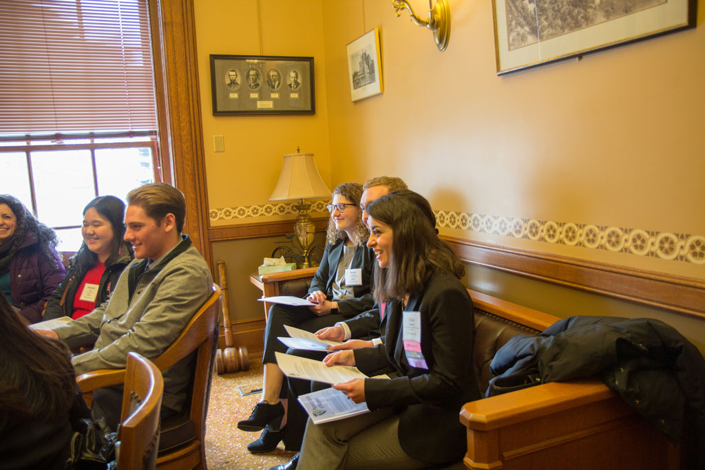 Group of students sitting around office and listening to legislator speak
