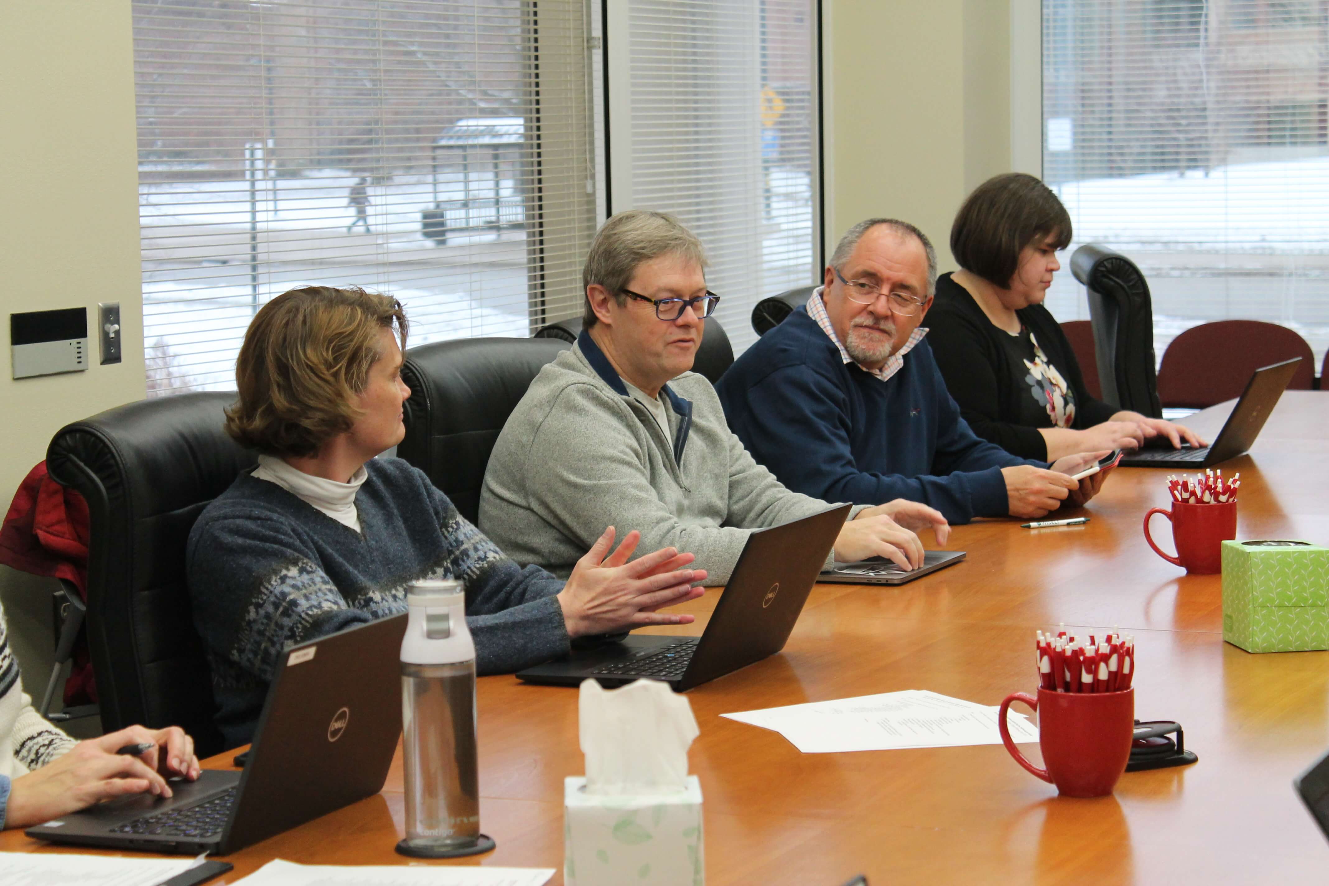 Chuck Lauhon and Mel de Villiers speaking in a meeting with campus partners