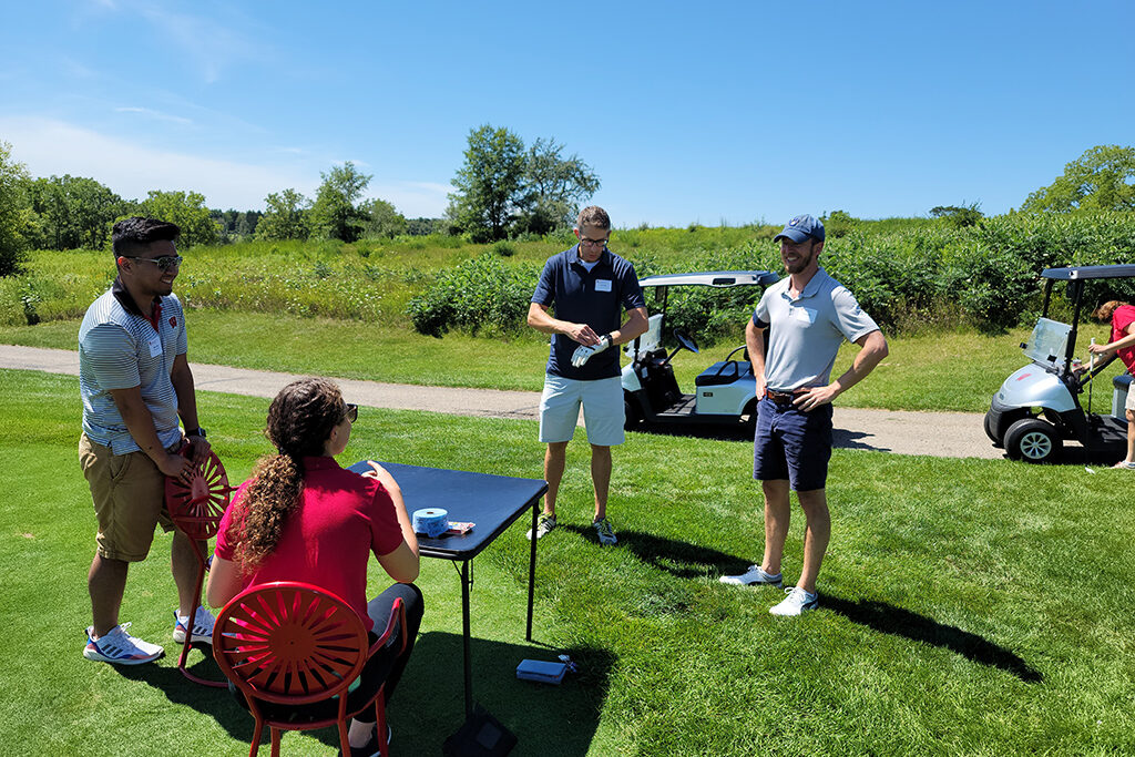 Pharm alum talking to check-in at golfing event