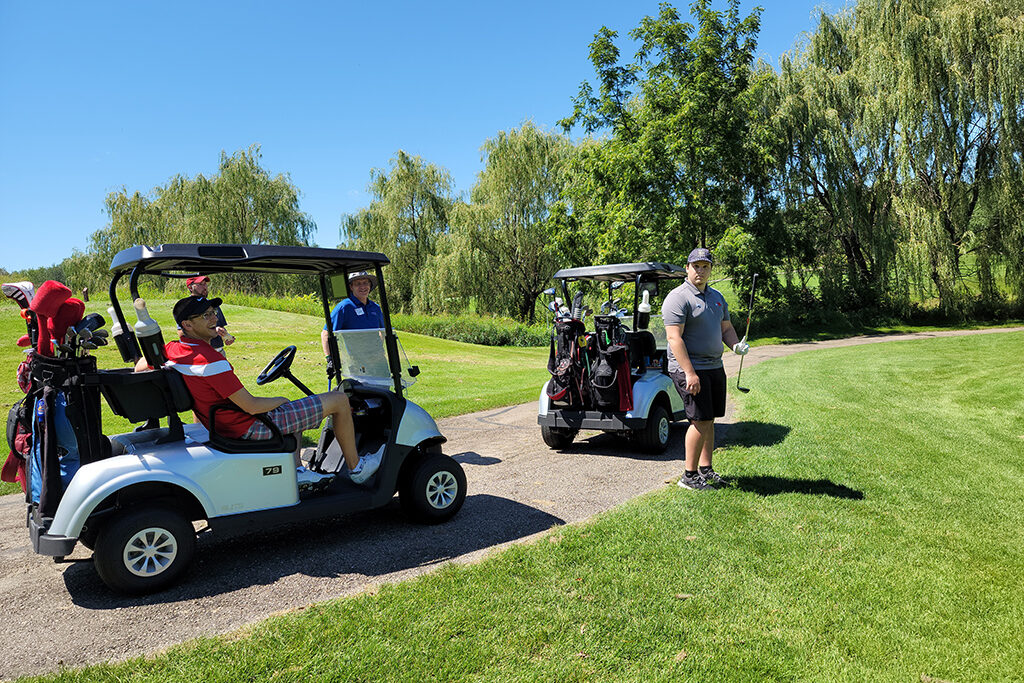 Pharm Alumni moving around on golf carts