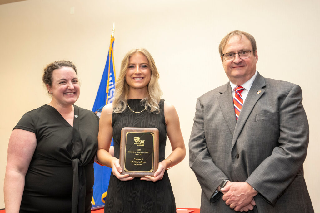 Chelsea Moyer poses with an award presenter and Dean Steve Swanson.