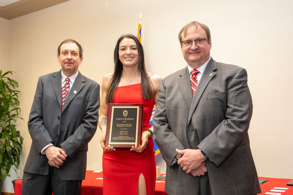 Ashley Srb poses with her award and Dean Steve Swanson and Eric Buxton.