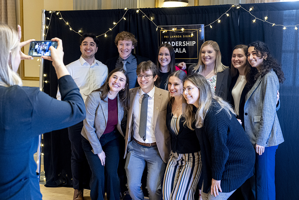 A group of PharmD students pose for a photo in front of a Leadership Gala sign.
