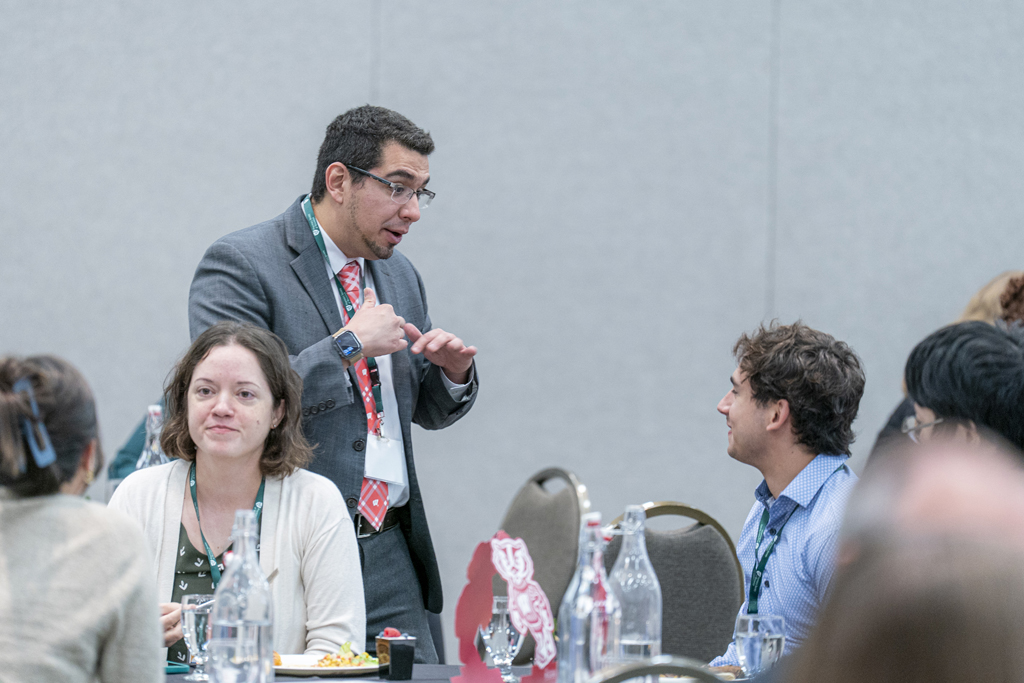 Ed Portillo speaks with a seated attendee