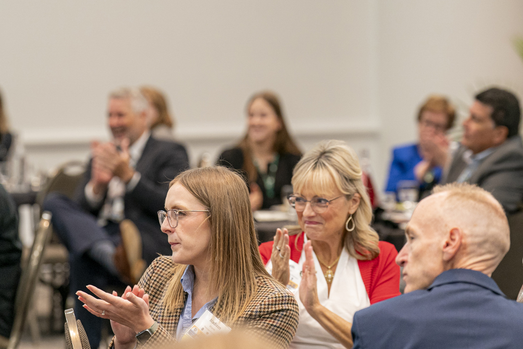 Attendees applaud from their tables