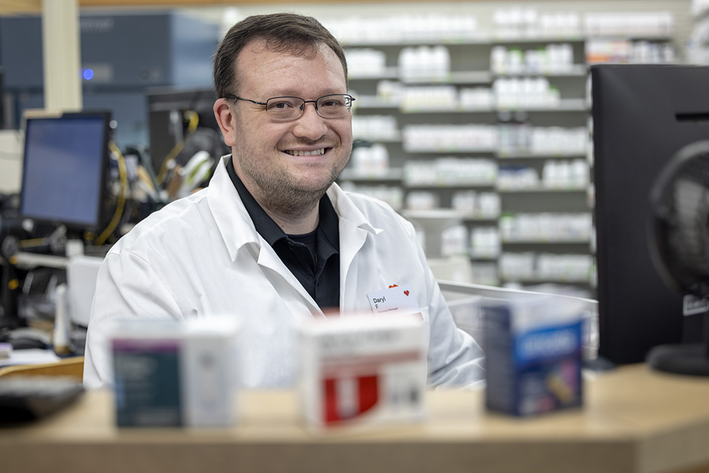 Daryl Fahrner smiles behind a pharmacy counter