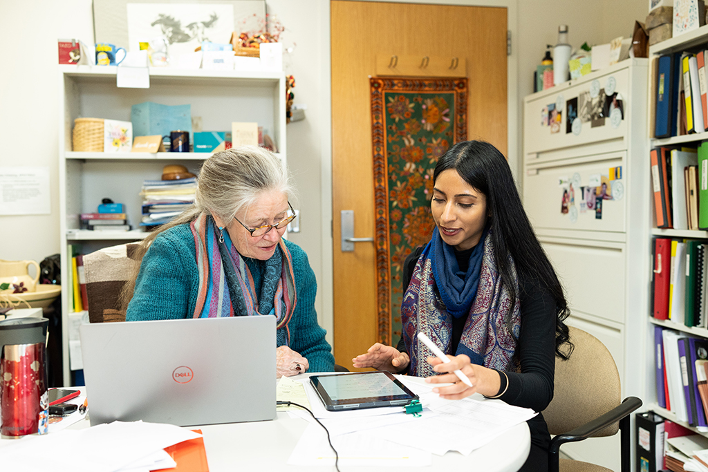 Betty Chewning and Apoorva Reddy look at a tablet together in Betty's office