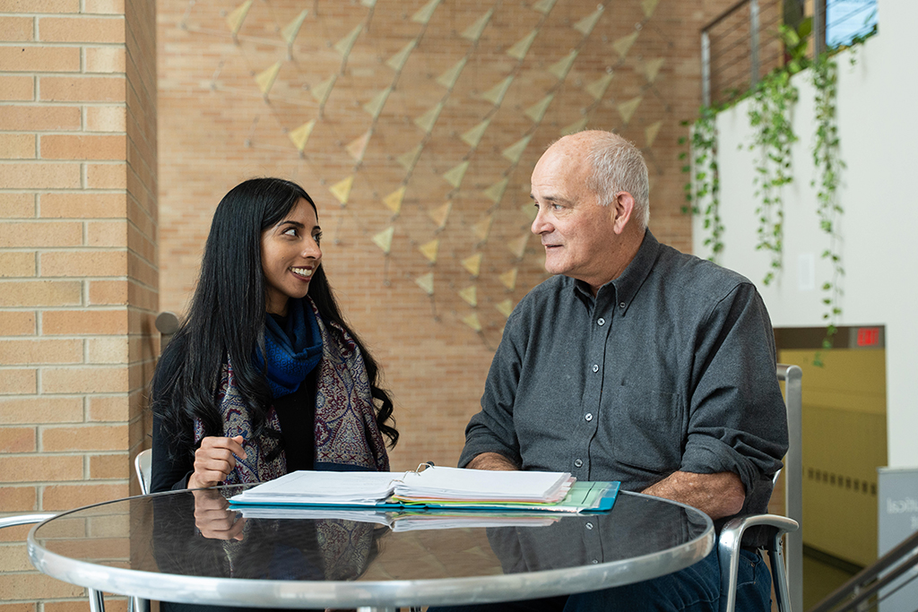 Paul Hutson and Apoorva Reddy pore over papers on a table