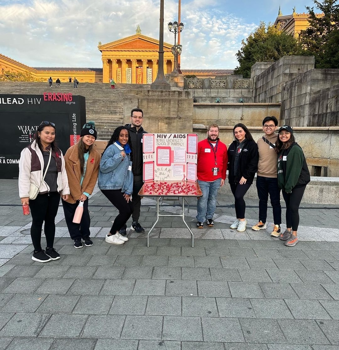 A group of people at an AIDS walk in Philadelphia, surrounding a table with information about HIV/AIDS.