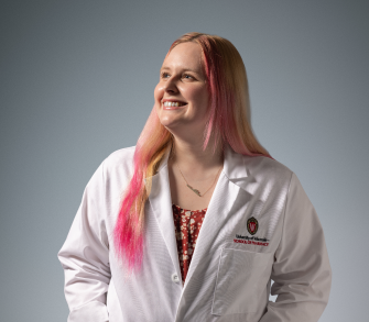 PharmD student in white coat looks upward
