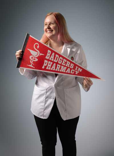 PharmD student Alyssa holding a Pharmacy Badgers pennant