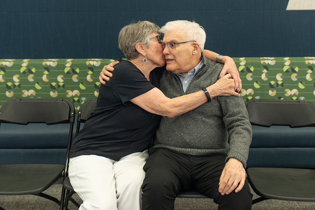 George Zografi getting a close hug from Pamela Ploetz while seated