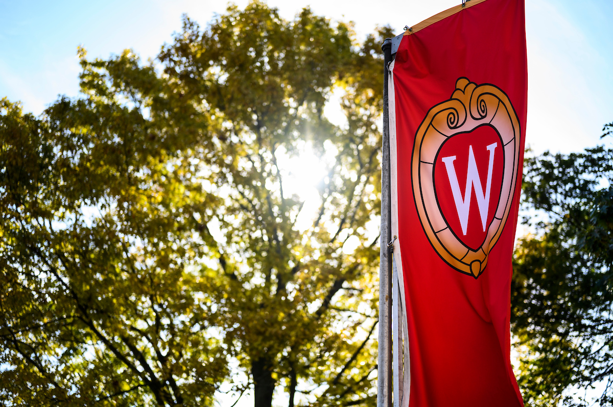 A W crest banner flutters in the wind on Bascom Hill at the University of Wisconsin-Madison during autumn