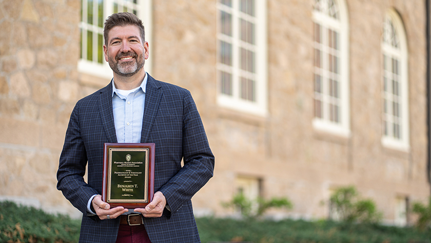 Ben White poses with his award plaque outside