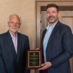 Professor Jeff Johnson, director of the School's Pharmacology and Toxicology program, presents Ben White with the PharmTox Alum of the Year plaque