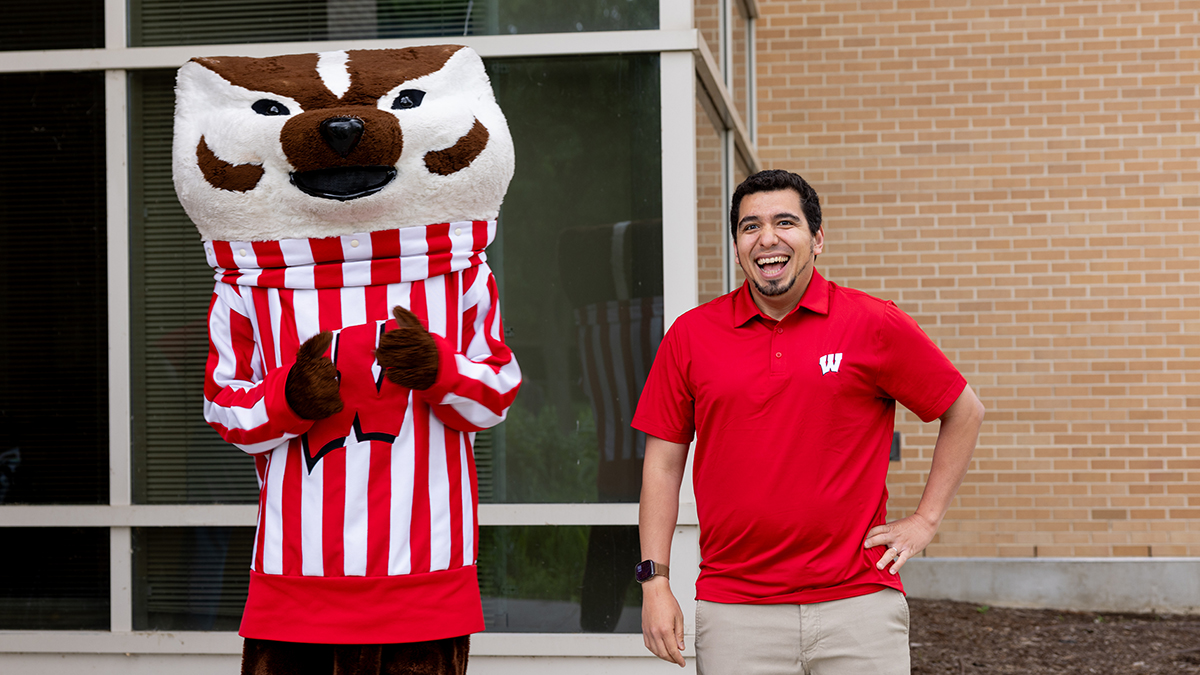 Bucky Badger and Ed Portillo pose by the School of Pharmacy