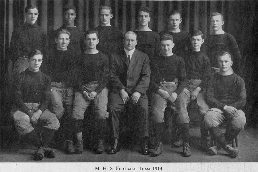 1914 Madison High School Football Team and coach. Leo Butts stands in the back row amongst a team of 12.