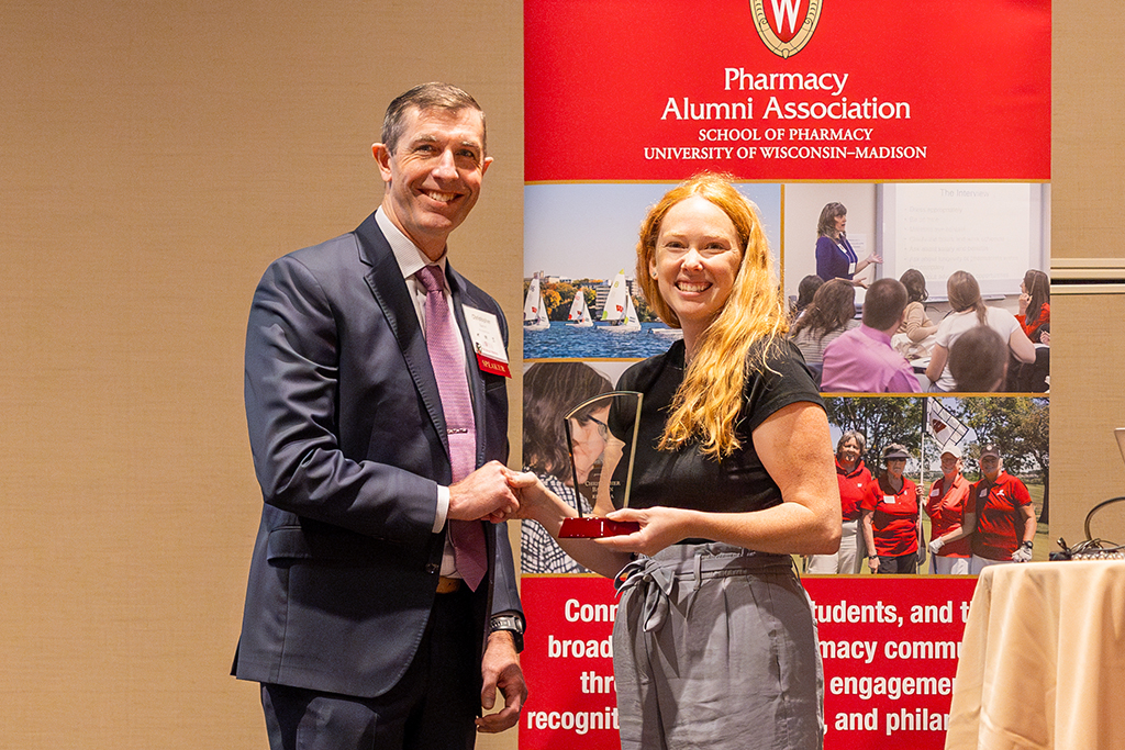 Heather Spatchek shakes Chris Barron's hand and gives him an award