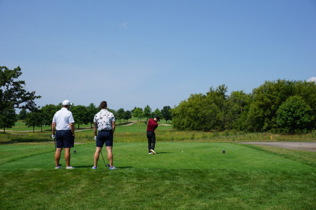 Alumni playing golf at a golf course