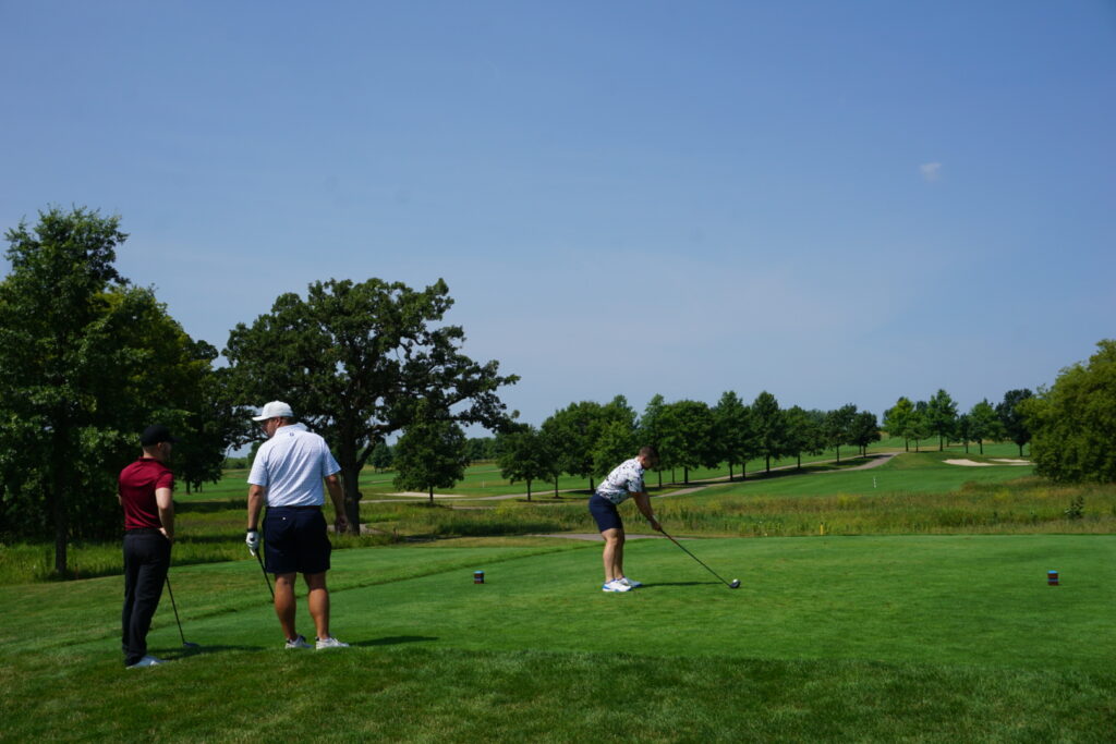 Alumni playing golf at a golf course