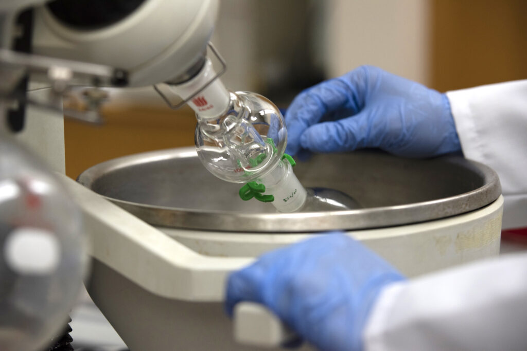 A close-up of the rotary evaporator shows the glass chambers used to heat and concentrate samples. 