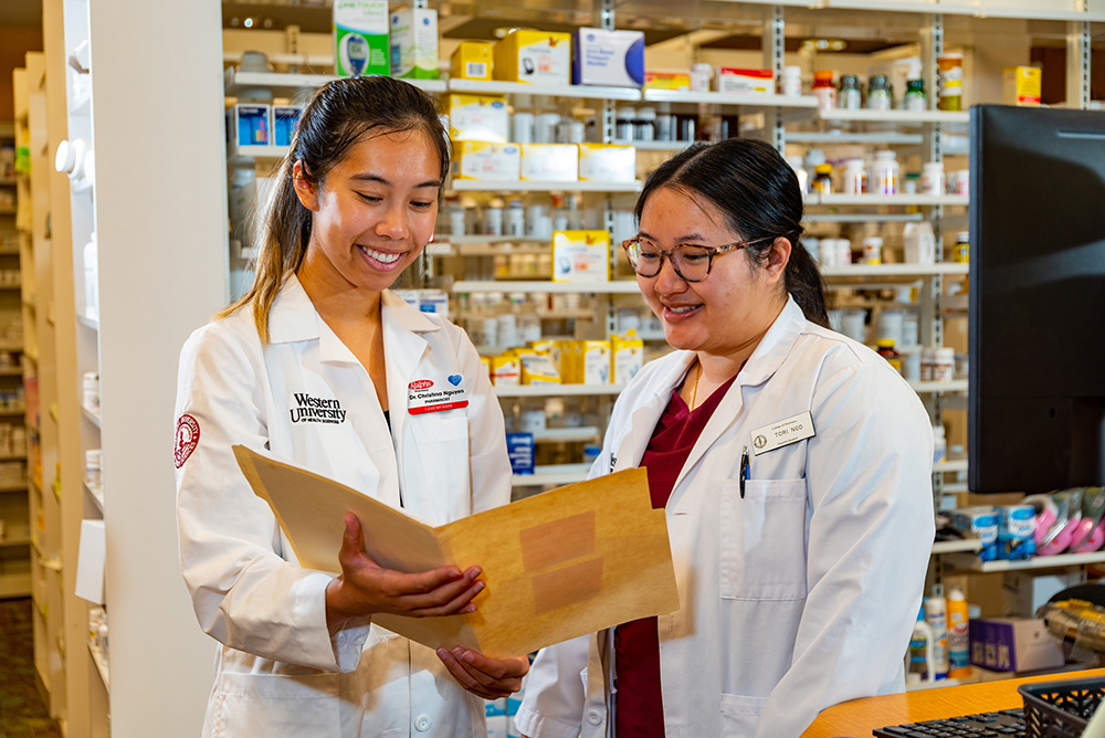 Christina Nguyen speaking with a colleague in the pharmacy
