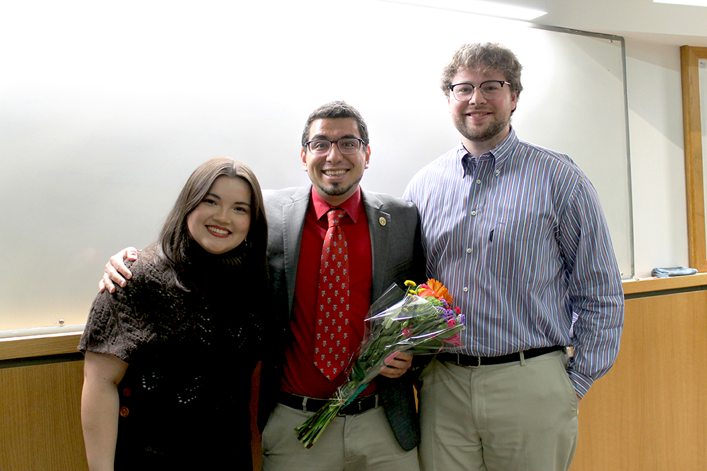 Ed Portillo receives flowers from two PharmD students