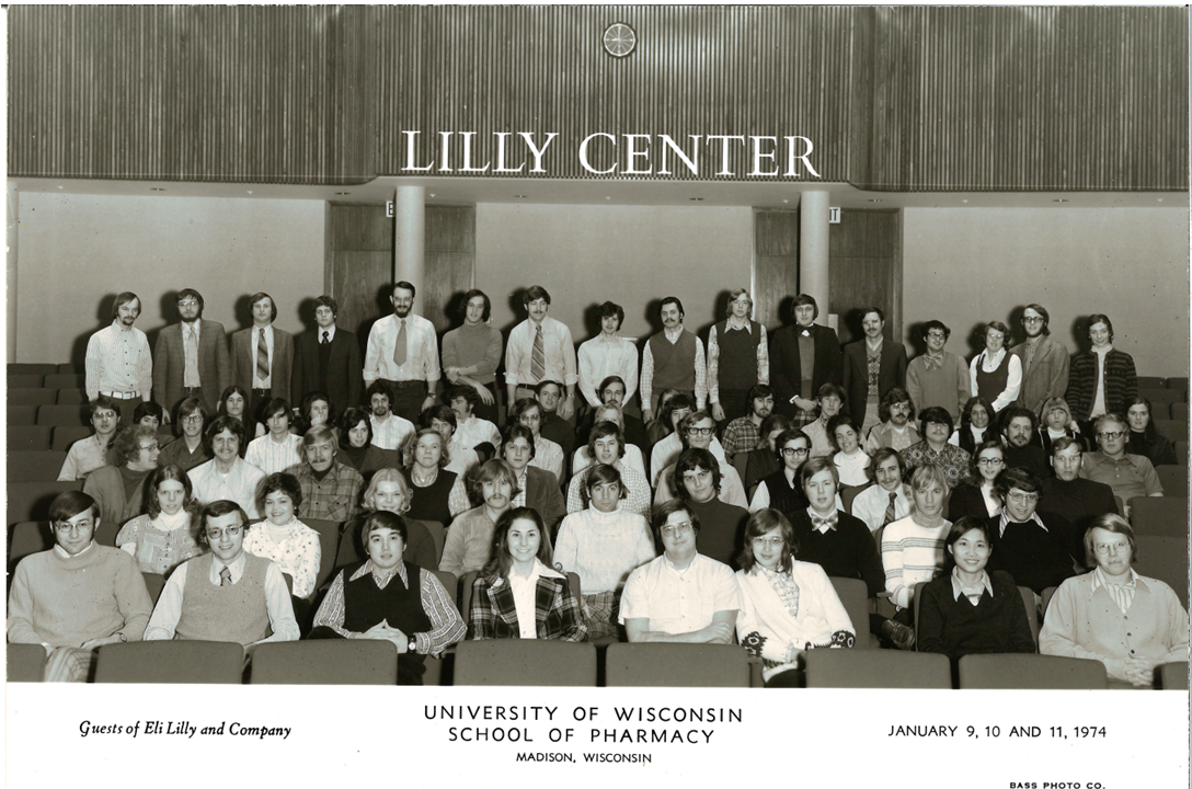 A black and white photo of a large group of people seated in an auditorium that says "Lilly Center" on the wall.