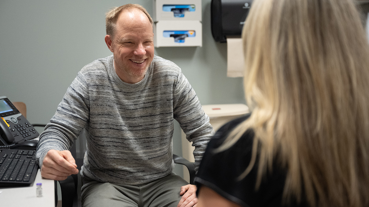 Eric Guerkink speaks with a woman in a clinic setting