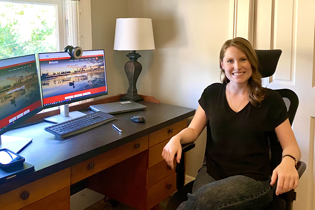 Erin Nowak smiles at her desk