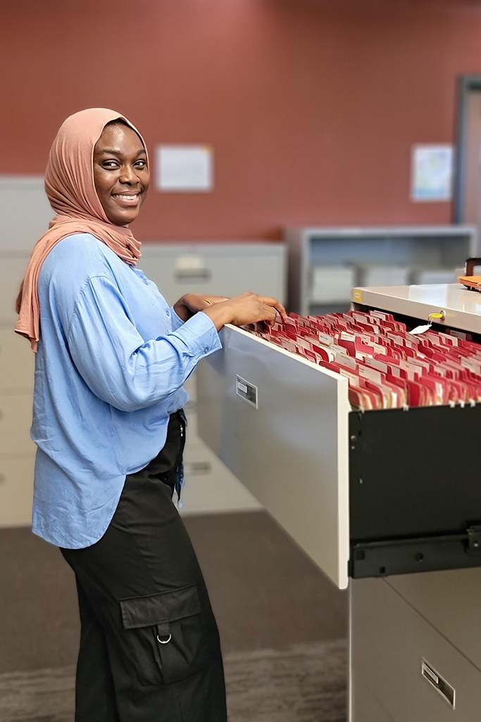 Fatima Abdul Rasheed by an open drawer of a filing cabinet