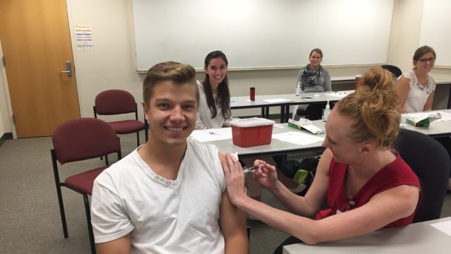 Andrew Vandermause receiving flu shot from Taylor Kitzke