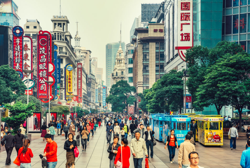 Busy street filled with people on Nanjing Road and colorful buildings