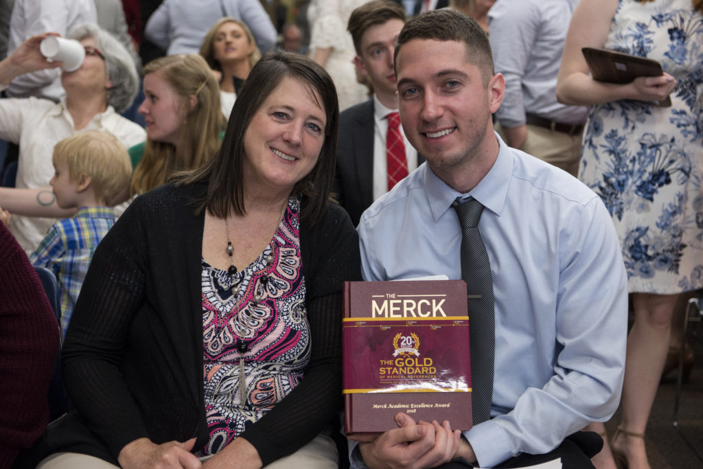 Jared Baxa holding the Merck manual with his mother