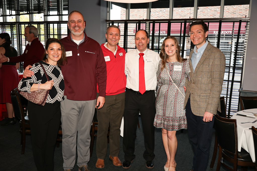 A group of alumni, including Angela de Ianni, Nick Ladell, Nick Olson, Mike Gillard, Marisa Gonien, and another attendee smile for a photo