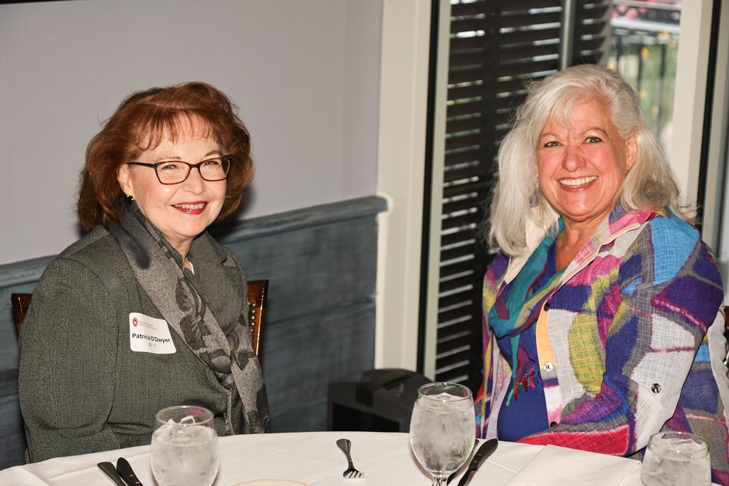 Patricia O'Dwyer and another alum smile at a table