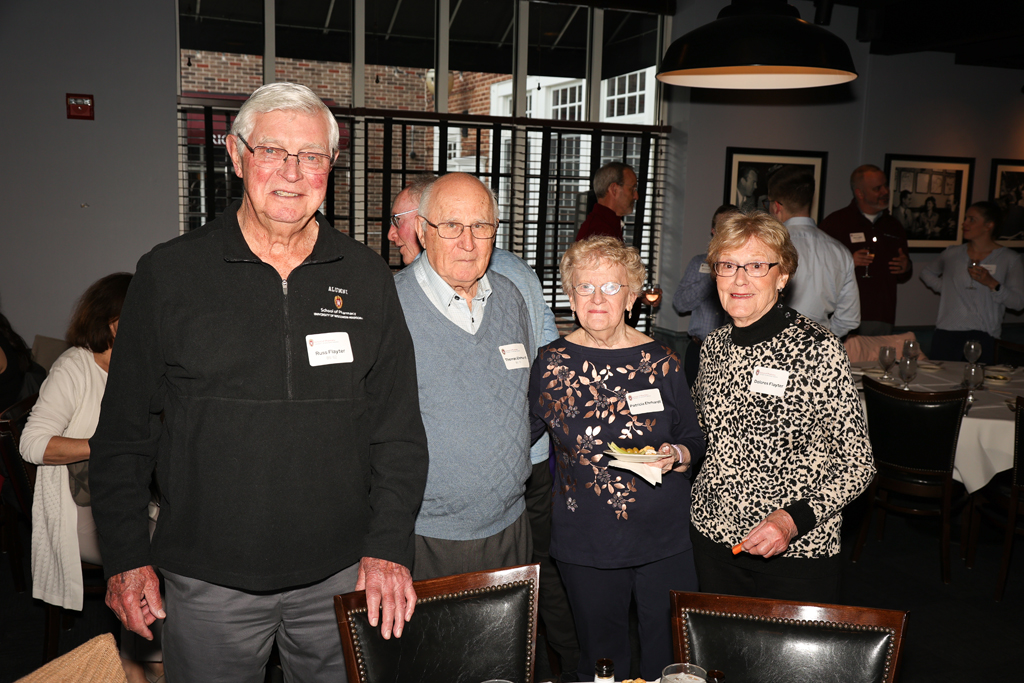 Russ Flayter, Delores Flayter, and two other alumni smile for a photo