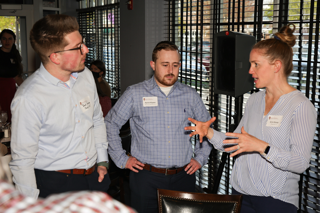 Erin Stoop, Aaron Klysen, and another alum talk in a group