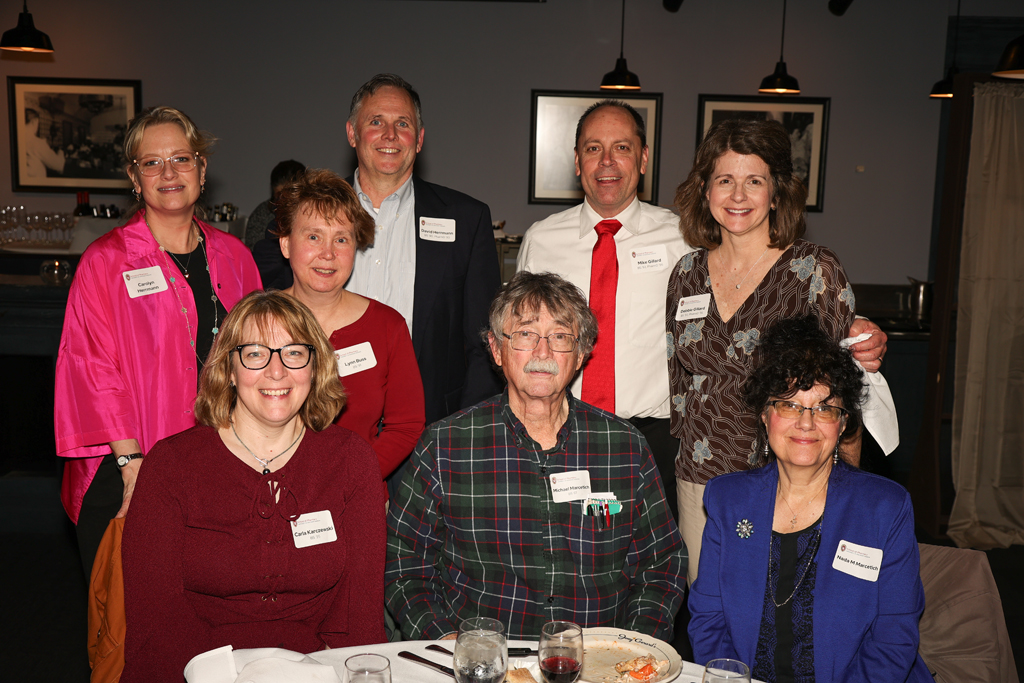 Group of alumni including Mike Gillard, Debbie Gillard, Carolyn Hermann, David Hermann, and others