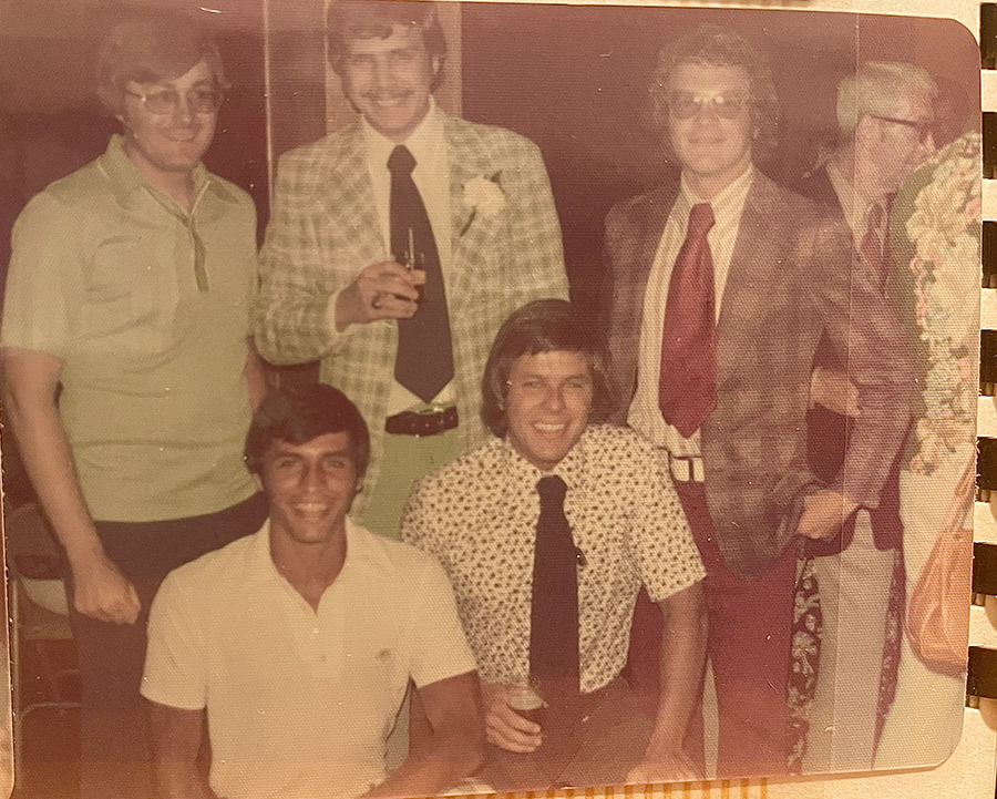 A group photo of four males in an old photo from the 70s