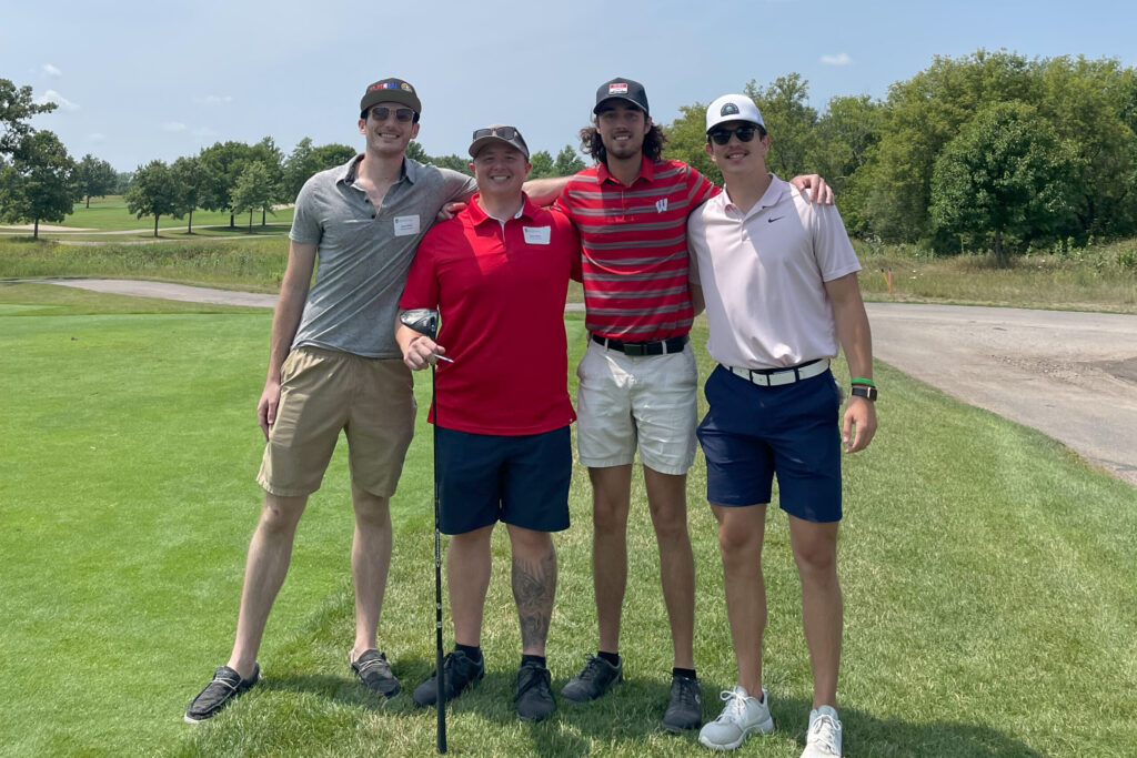 Students with alumni at a golf course
