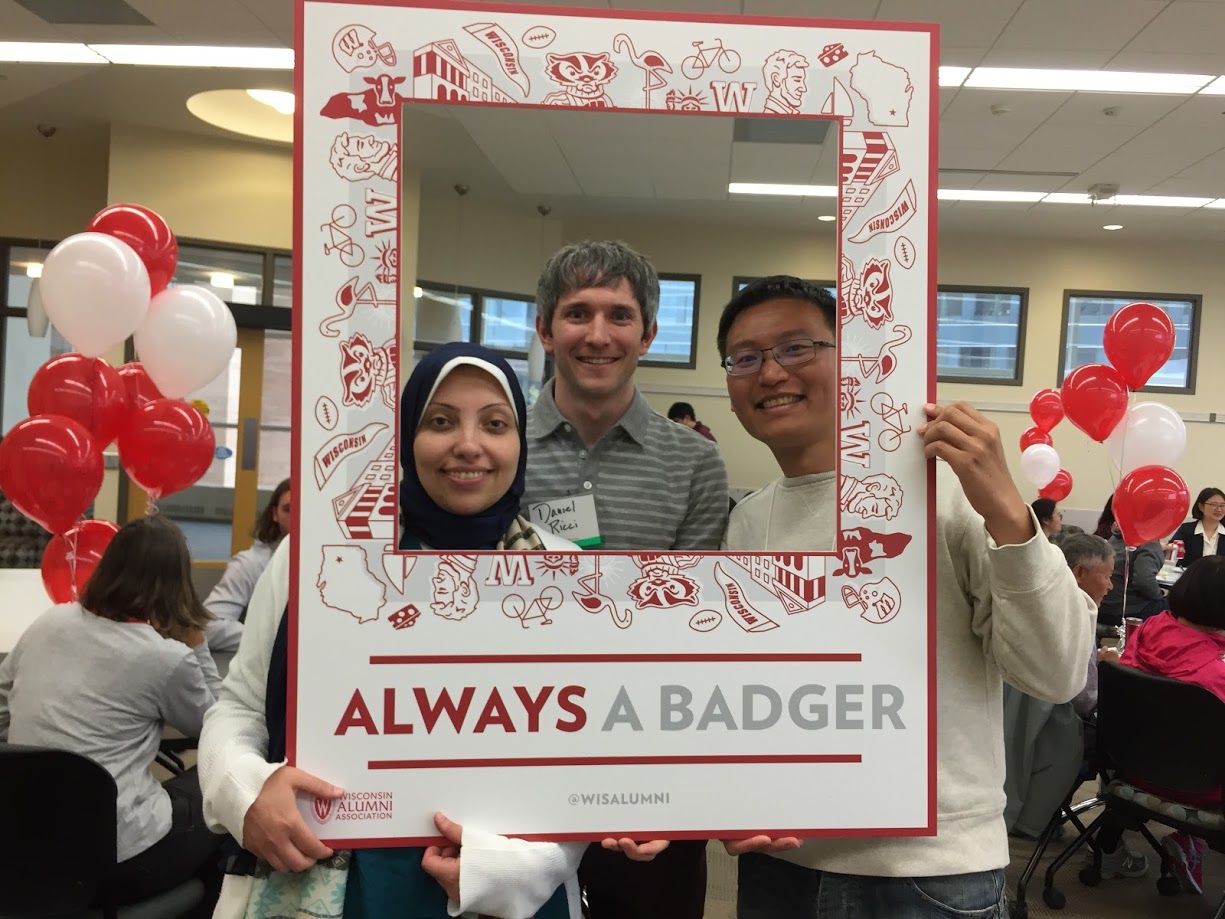 Students pose for a photograph with a sign.