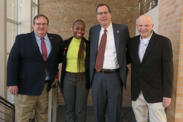 Steve Swanson, Cierra Brewer, Provost Karl Scholz, and Ron Burnette all standing arm-in-arm in Rennebohm Hall