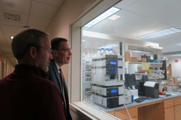 Dave Mott and Provost Karl Scholz looking into a pharmaceutical lab