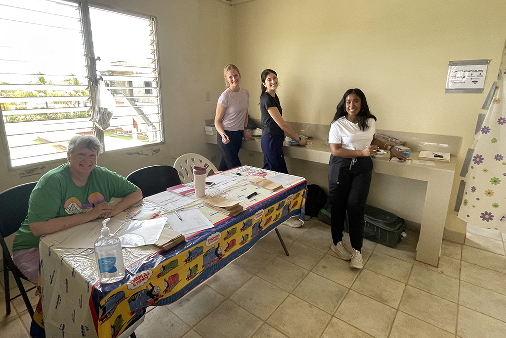 Karen Kopacek seated at a table, with Jasmine Kuhnhenn, Katherine Kitslaar and Sadiyya Rahaman to the right
